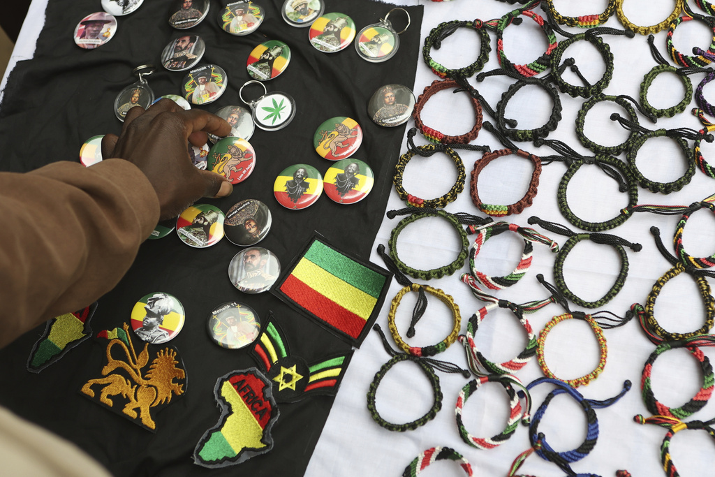 A buyer purchases Rastafarian-branded items during a celebration marking 133 years since the birth of Haile Selassie I at the Kenya National Theatre in Nairobi, Kenya, Wednesday, July 23, 2025. (AP Photo/Andrew Kasuku)