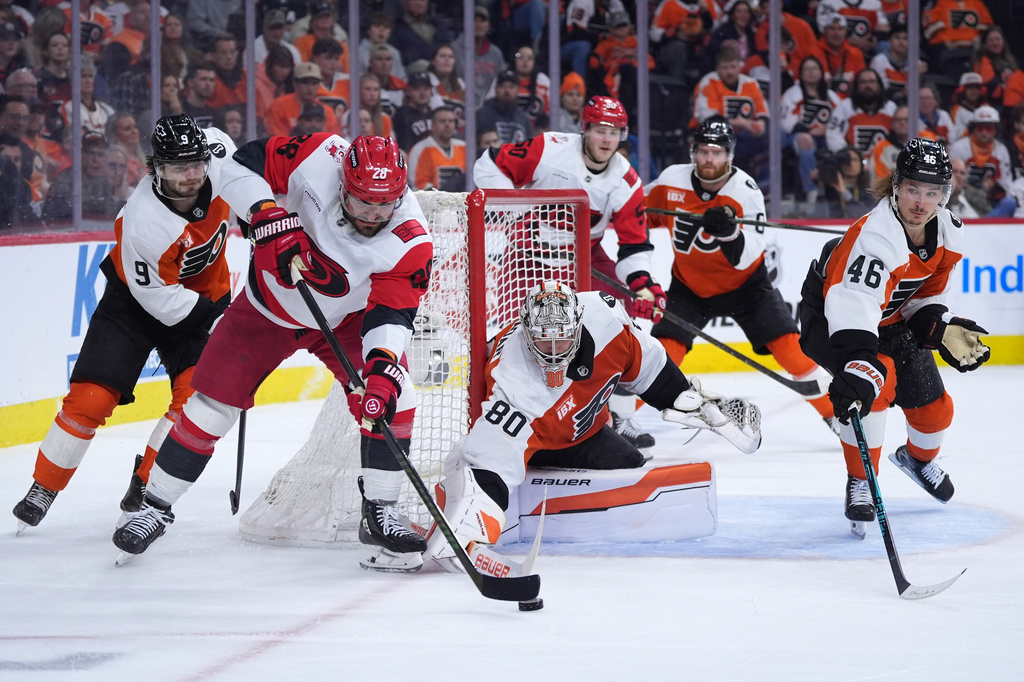 FILE - Carolina Hurricanes' William Carrier (28) tries to get the puck past Philadelphia Flyers' Dan Vladar (80), Trevor Zegras (46) and Jamie Drysdale (9) during the third period of Game 4 in a second-round NHL hockey Stanley Cup playoff series, May 9, 2026, in Philadelphia. (AP Photo/Matt Slocum, File)