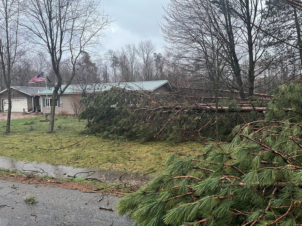 This photo provided by Kronenwetter Police Dept., shows damage to a house and fallen trees after severe weather passed the area on Friday, April 17, 2026 in Kronenwetter, Wis. (Kronenwetter Police Chief Terry P. McHugh/Kronenwetter Police Dept. via AP)