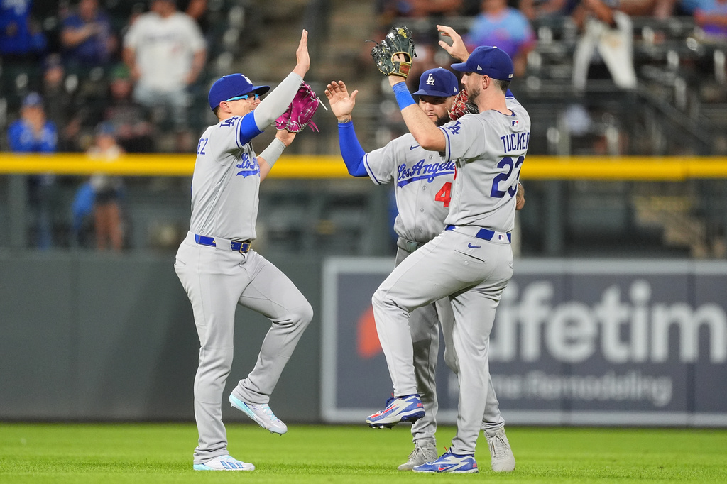 Los Angeles Dodgers left fielder Enrique Hern·ndez, left, celebrates with center fielder Andy Pages and right fielder Kyle Tucker, right, after defeating the Colorado Rockies in a baseball game Tuesday, Aug. 18, 2026, in Denver. (AP Photo/David Zalubowski)
