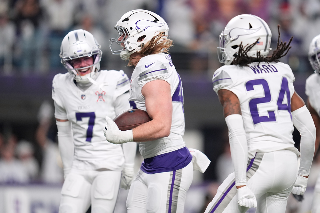 Minnesota Vikings linebacker Andrew van Ginkel, center, celebrates with cornerback Byron Murphy Jr., left, and safety Jay Ward after recovering a fumble by Detroit Lions quarterback Jared Goff, not pictured, during the first half of an NFL football game, Thursday, Dec. 25, 2025, in Minneapolis. (AP Photo/Abbie Parr)