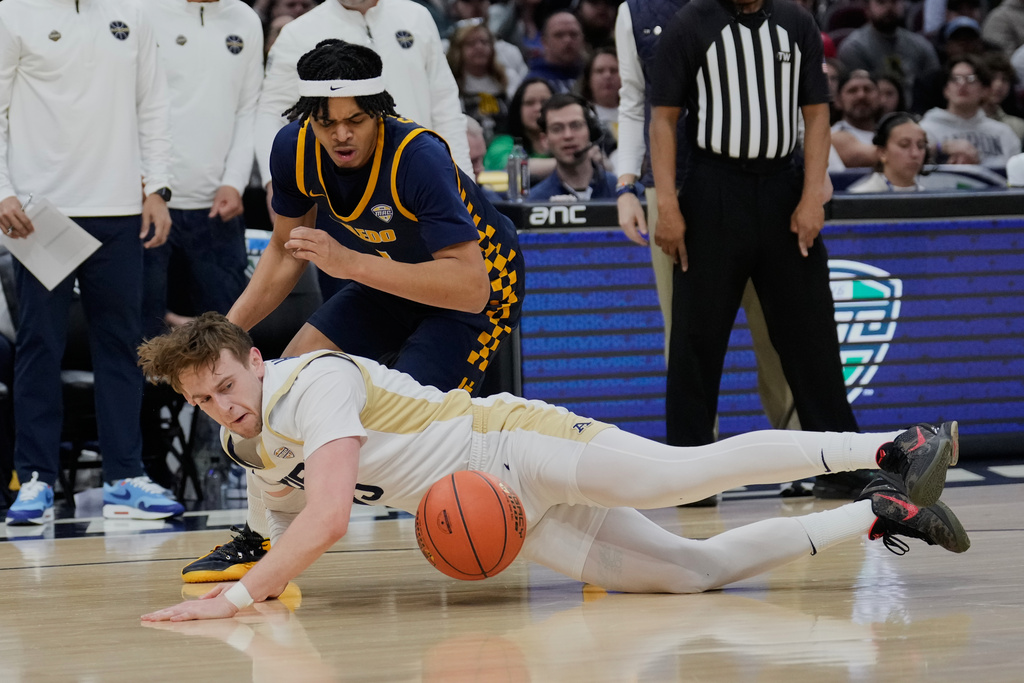 Akron guard Bowen Hardman, front, dives for the ball in front of Toledo guard Mynor Strong, rear, in the first half of an NCAA college basketball game in the championship of the Mid-American Conference tournament, Saturday, March 14, 2026, in Cleveland. (AP Photo/Sue Ogrocki)