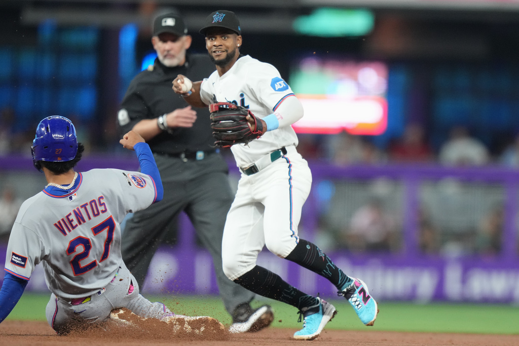 New York Mets' Mark Vientos (27) is out at second as Miami Marlins second baseman Xavier Edwards, right, throws to first for a double play during the second inning of a baseball game, Saturday, May 23, 2026, in Miami. (AP Photo/Lynne Sladky)