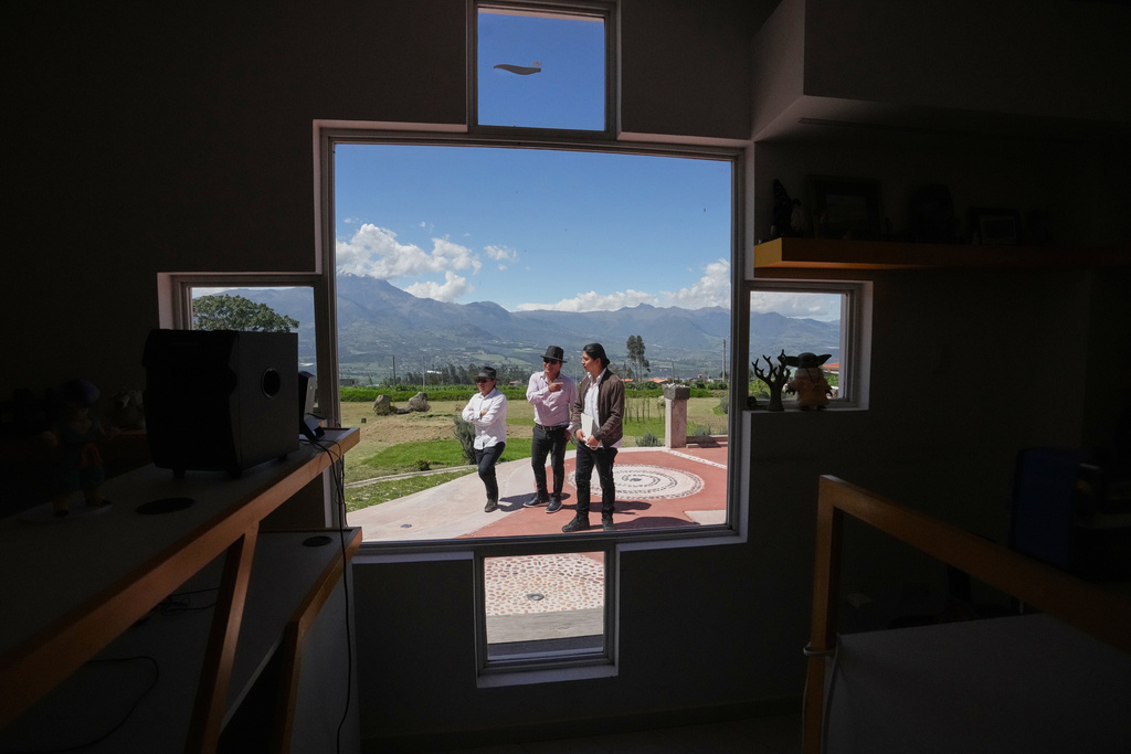 From left, Malkik Anrango, Tupac Amaru and Yarik Sisa chat about "Aya Somos," the first Quichua animated short, blending Otavalo culture with Japanese-style anime, in the courtyard of the Yay Animación studio in Hatun Rumi, Ecuador, Wednesday, Dec. 3, 2025. (AP Photo/Dolores Ochoa)