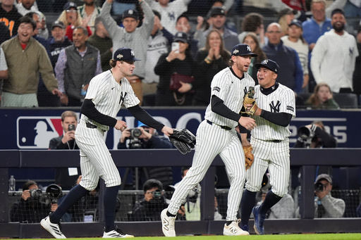 New York Yankees third base Ryan McMahon, center, is congratulated by pitcher Cam Schlittler, left, and shortstop Anthony Volpe after making a catch over the Boston Red Sox dugout during the eighth inning of Game 3 of an American League wild-card baseball playoff series, Thursday, Oct. 2, 2025, in New York. (AP Photo/Frank Franklin II) New York Yankees third base Ryan McMahon, center, is congratulated by pitcher Cam Schlittler, left, and shortstop Anthony Volpe after making a catch over the Boston Red Sox dugout during the eighth inning of Game 3 of an American League wild-card baseball playoff series, Thursday, Oct. 2, 2025, in New York. (AP Photo/Frank Franklin II)
