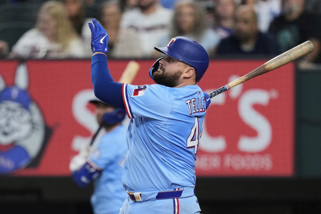 Texas Rangers' Rowdy Tellez (44) follows through on a two-run home run swing during the fourth inning of a baseball game against the Cleveland Guardians Sunday, Aug. 24, 2025, in Arlington, Texas. (AP Photo/Tony Gutierrez)
