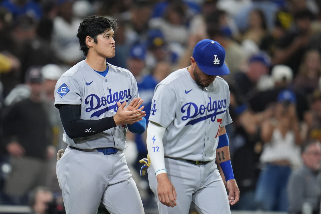 Los Angeles Dodgers starting pitcher Shohei Ohtani, left, celebrates with teammate Miguel Rojas after the Dodgers defeated the San Diego Padres 4-0 in a baseball game Wednesday, May 20, 2026, in San Diego. (AP Photo/Gregory Bull)