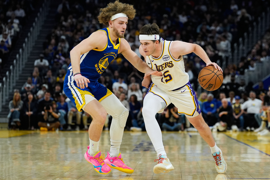 Los Angeles Lakers guard Austin Reaves (15) moves the ball while defended by Golden State Warriors guard Brandin Podziemski (2) during the first half of an NBA basketball game, Saturday, Feb. 28, 2026, in San Francisco. (AP Photo/Godofredo A. Vásquez)