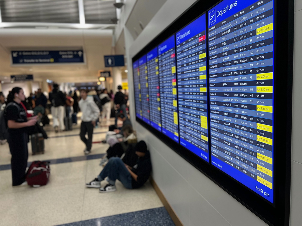 A departure board lists delayed and cancelled flights at O'Hare International Airport, Sunday, Nov. 30, 2025, in Chicago. (AP Photo/Adam Schreck)