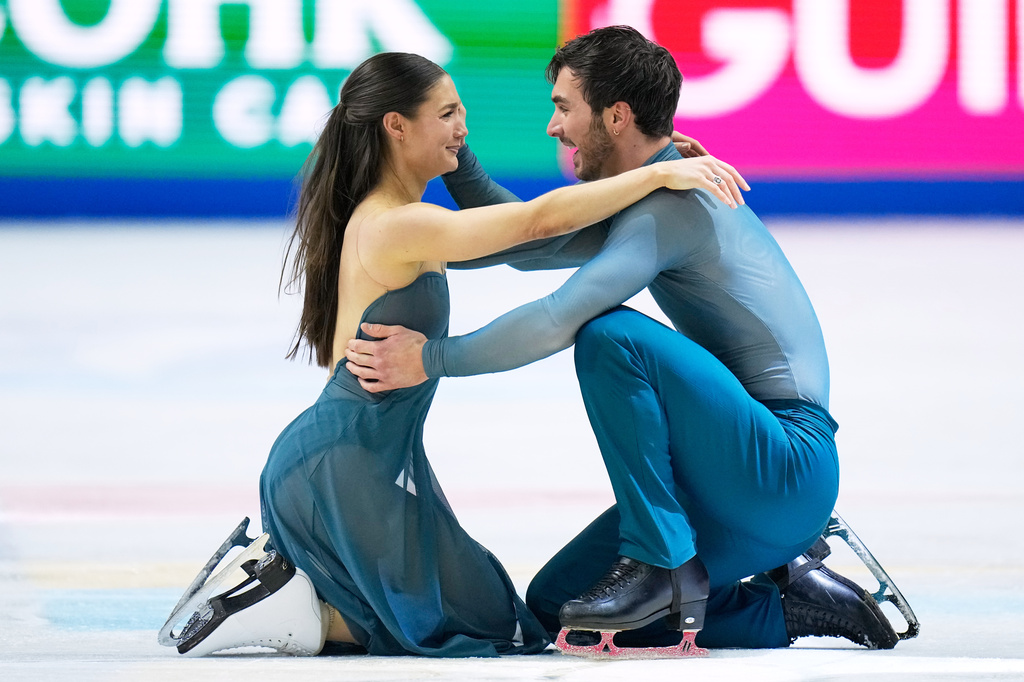 Laurence Fournier Beaudry and Guillaume Cizeron from France hug after competing during the ice dance free dance at the Figure Skating World Championships in Prague, Czech Republic, Saturday, March 28, 2026. (AP Photo/Petr David Josek)