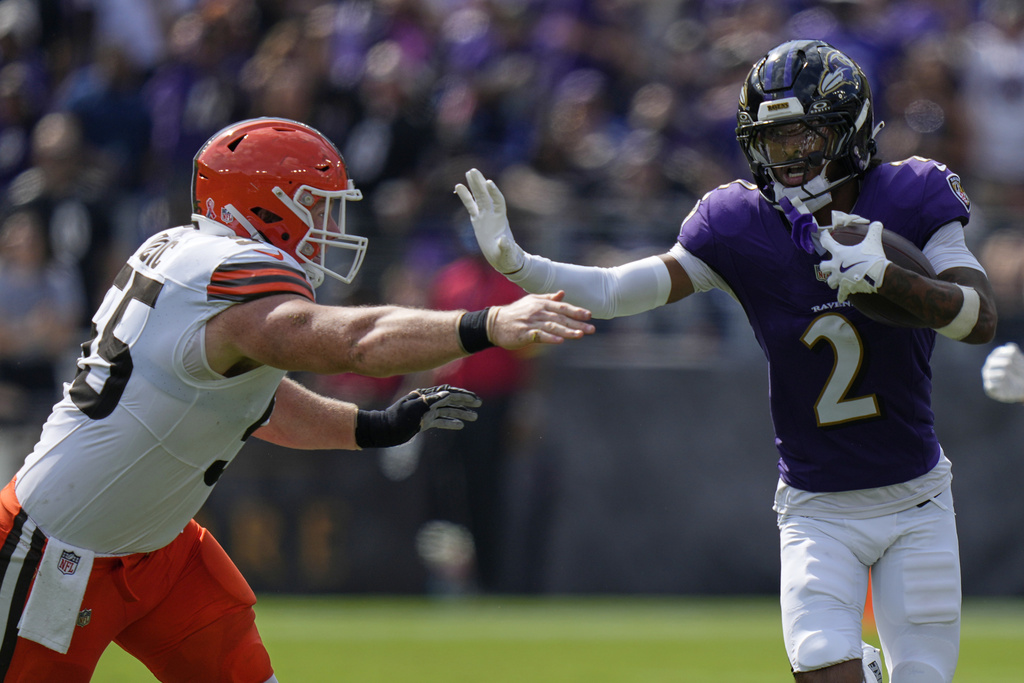 Baltimore Ravens cornerback Nate Wiggins runs past Cleveland Browns center Ethan Pocic after an interception during the second half of an NFL football game, Sunday, Sept. 14, 2025, in Baltimore. (AP Photo/Stephanie Scarbrough)