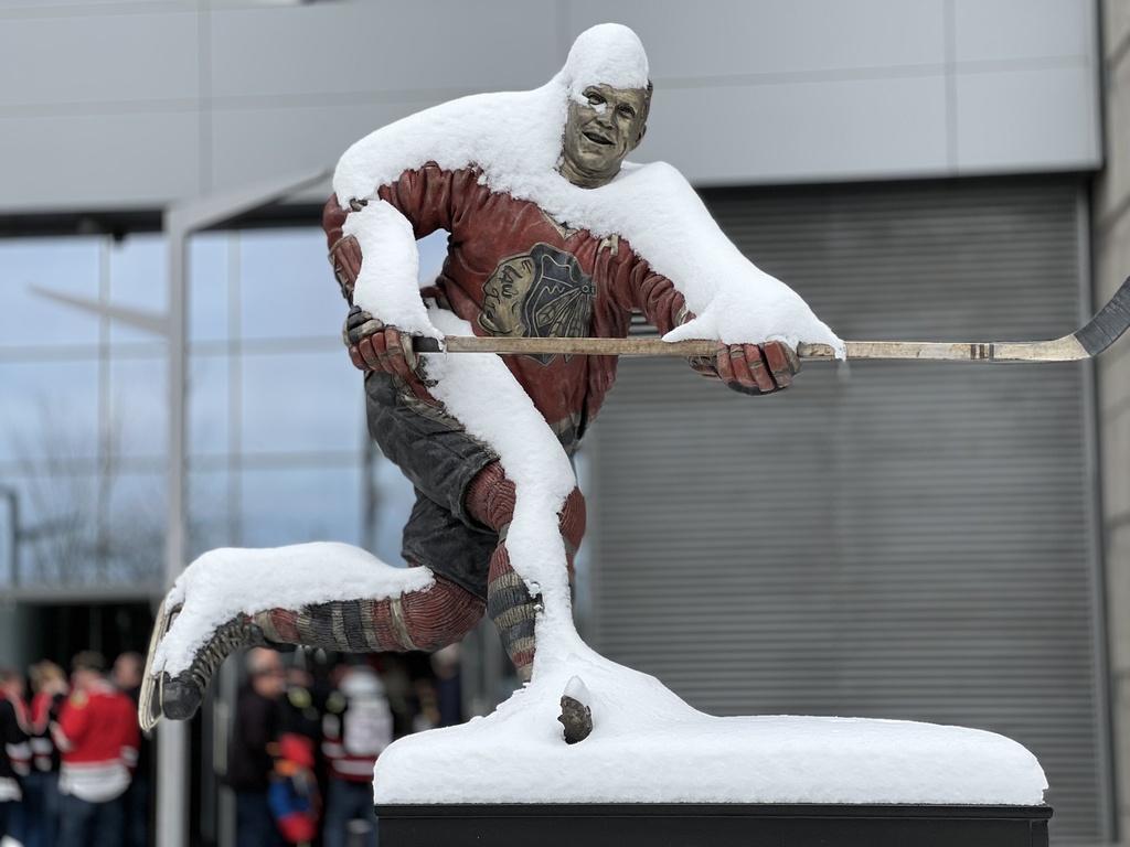 A statue of former Chicago Blackhawks' Bobby Hull is covered in snow before a NHL hockey game between the Chicago Blackhawks and the Anaheim Ducks, Sunday, Nov. 30, 2025, in Chicago. (AP Photo/David Banks)