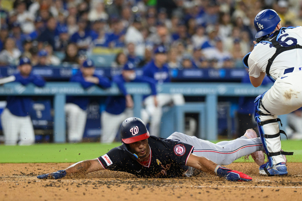 Washington Nationals' Daylen Lile, left, slides to score past Los Angeles Dodgers catcher Will Smith on a two-run double by Harry Ford during the fourth inning of a baseball game in Los Angeles, Sunday, Sept. 6, 2026. (AP Photo/Kyusung Gong)