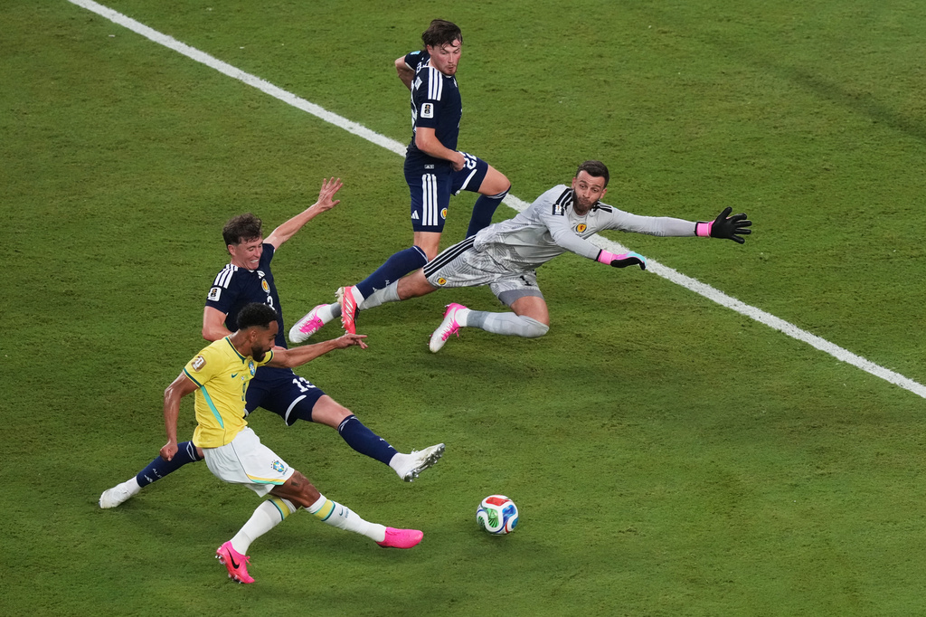 Brazil's Matheus Cunha (9) scores a goal on Scotland goalkeeper Angus Gunn (1) during the World Cup Group C soccer match in Miami Gardens, Fla., Wednesday, June 24, 2026. (AP Photo/Marta Lavandier)