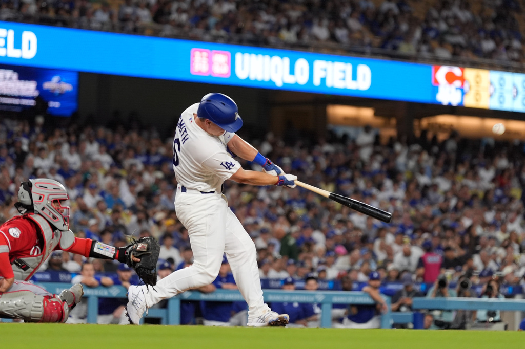 Los Angeles Dodgers' Will Smith, right, hits a solo home run as Cincinnati Reds catcher Jose Trevino watches during the first inning of a baseball game Tuesday, Sept. 8, 2026, in Los Angeles. (AP Photo/Mark J. Terrill)