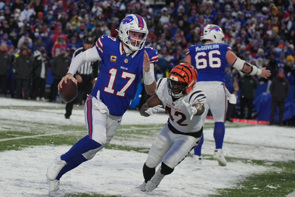 Buffalo Bills quarterback Josh Allen (17) scrambles away from Cincinnati Bengals linebacker Oren Burks (42) during the second half of an NFL football game, Sunday, Dec. 7, 2025, in Orchard Park, N.Y. (AP Photo/Gene J. Puskar)