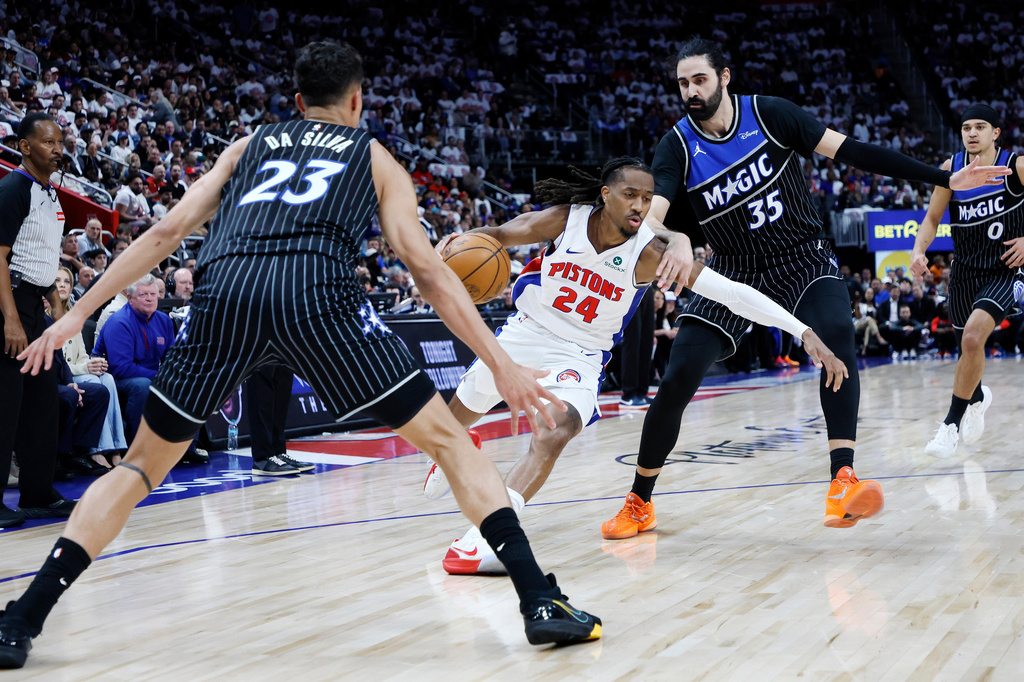 Detroit Pistons guard Daniss Jenkins (24) drives to the basket against Orlando Magic forward Tristan da Silva (23) and center Goga Bitadze (35) during the first half in Game 2 of a first-round NBA basketball playoffs series Wednesday, April 22, 2026, in Detroit. (AP Photo/Duane Burleson)