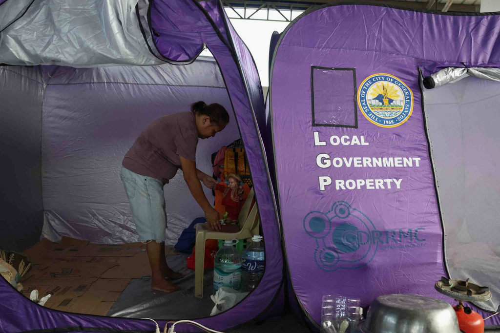 Mary Jean Lacsi takes shelter at a covered court turned into an evacuation center in General Santos, southern Philippines, Thursday, June 11, 2026, after Monday's earthquake destroyed her home. (AP Photo/Basilio Sepe)