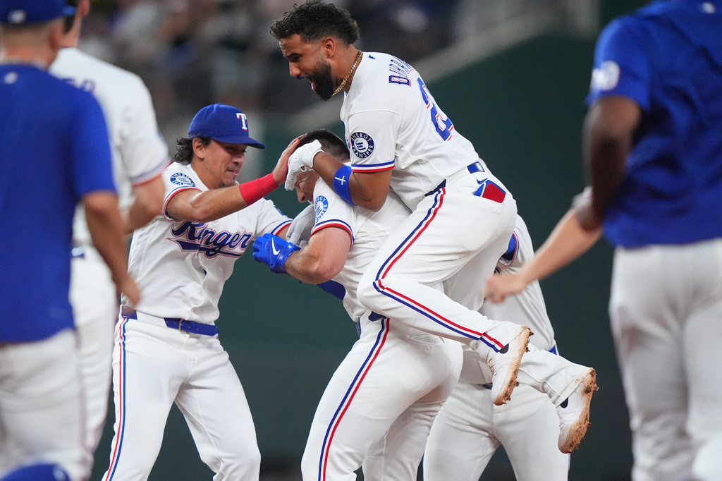 Texas Rangers' Ezequiel Duran (20) and Nicky Lopez, left, celebrates with Wyatt Langford a game winning single in the ninth inning of a baseball game against the Los Angeles Angels, Thursday, July 9, 2026, in Arlington, Texas. (AP Photo/LM Otero)