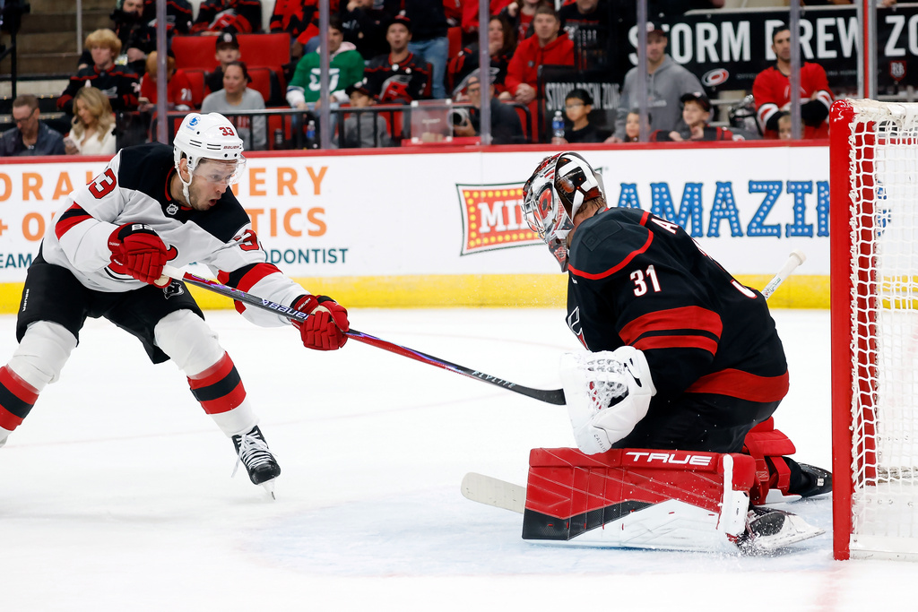 Carolina Hurricanes goaltender Frederik Andersen (31) blocks a shot by New Jersey Devils' Evgenii Dadonov (33) during the first period of an NHL hockey game in Raleigh, N.C., Thursday, Oct. 9, 2025. (AP Photo/Karl DeBlaker)