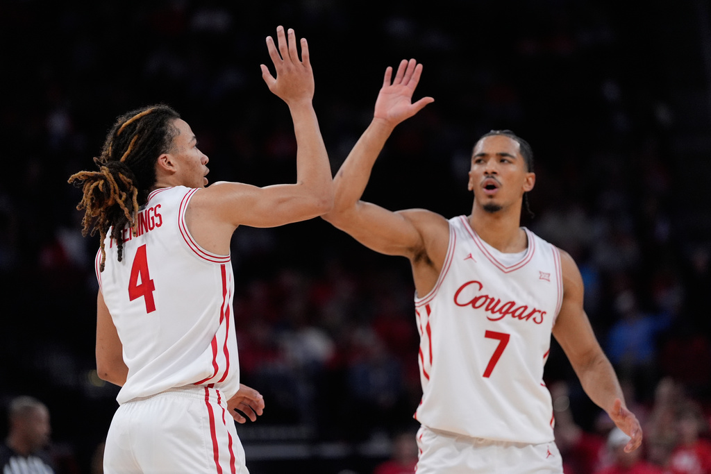 Houston guard Kingston Flemings (4) celebrates with guard Milos Uzan (7) during the second half of an NCAA college basketball game against Florida State in Houston, Saturday, Dec. 6, 2025. (AP Photo/Ashley Landis)