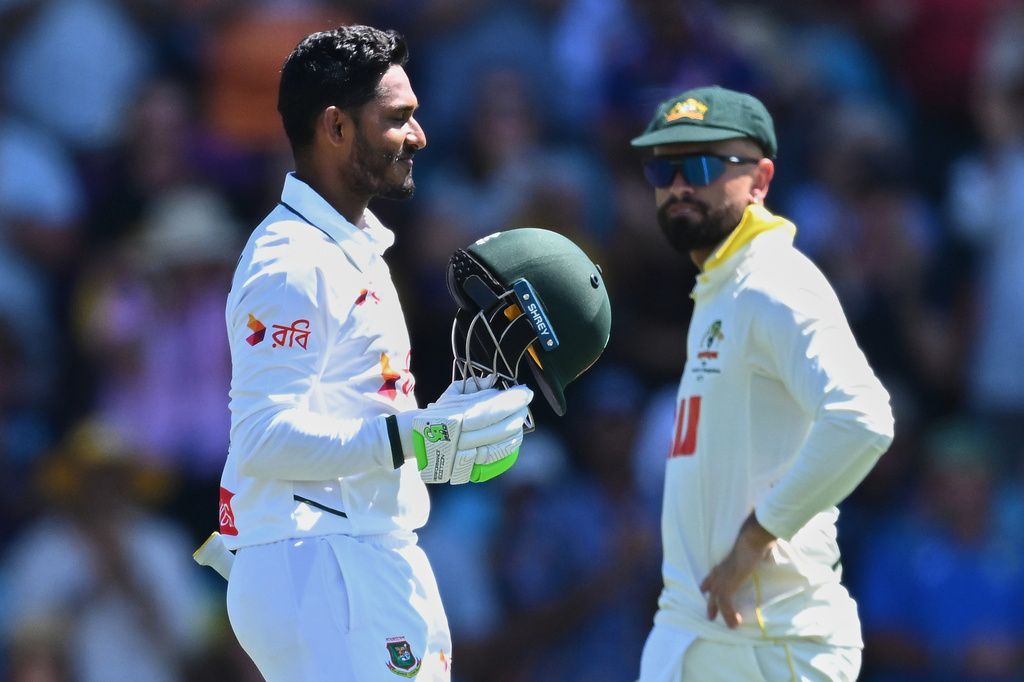 Tanzid Hasan Tamid of Bangladesh, left, celebrates scoring a century as Australia's Jake Weatherald watches during play on day two of the first cricket test in Darwin, Australia, Friday, Aug.14, 2026. (James Ross/AAPImage via AP)