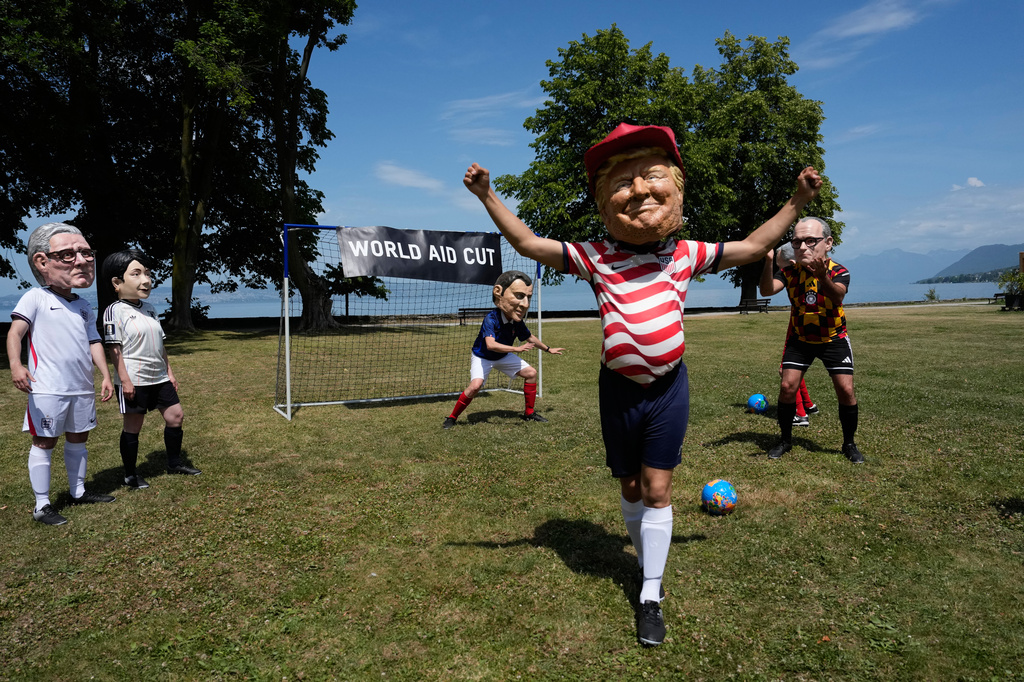 Oxfam's satirical 'big heads' of the G7 leaders pose dressed as soccer players at the soccer World Cup as a referee shows them a red card, during the G7 summit in Public, near Evian-les-Bains, France, Tuesday, June 16, 2026. (AP Photo/Christophe Ena)