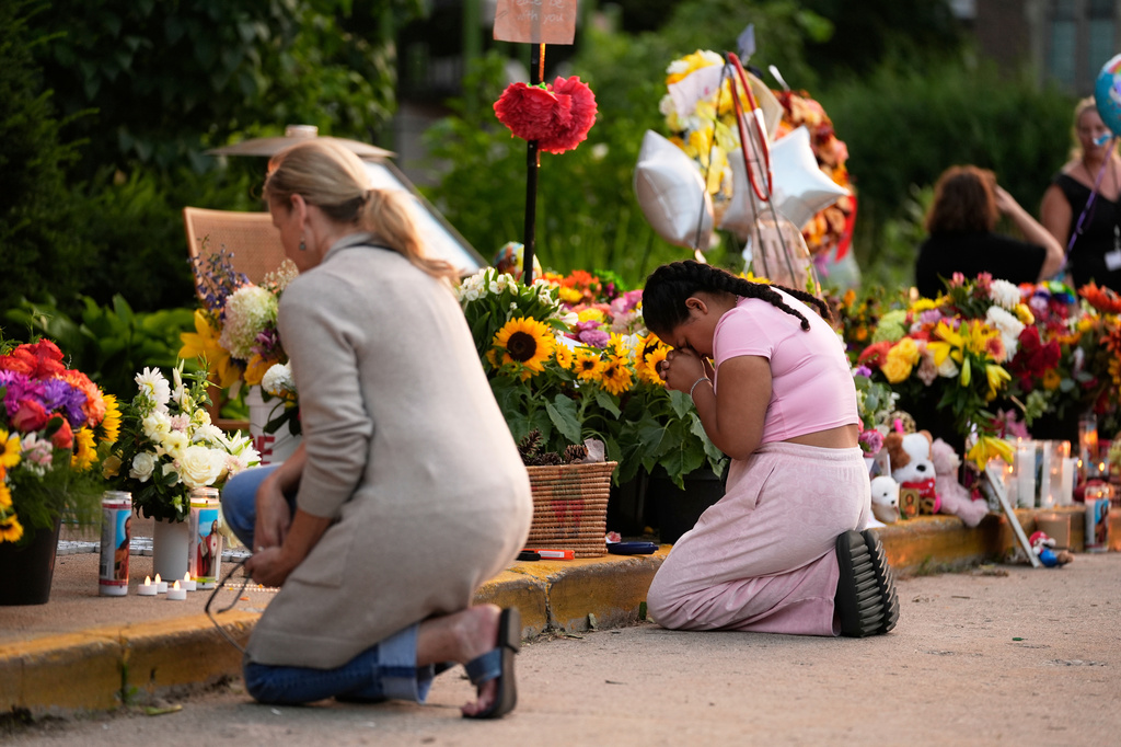 FILE - People pray at a memorial at Annunciation Catholic Church the day after a school shooting, Aug. 28, 2025, in Minneapolis. (AP Photo/Abbie Parr, File)