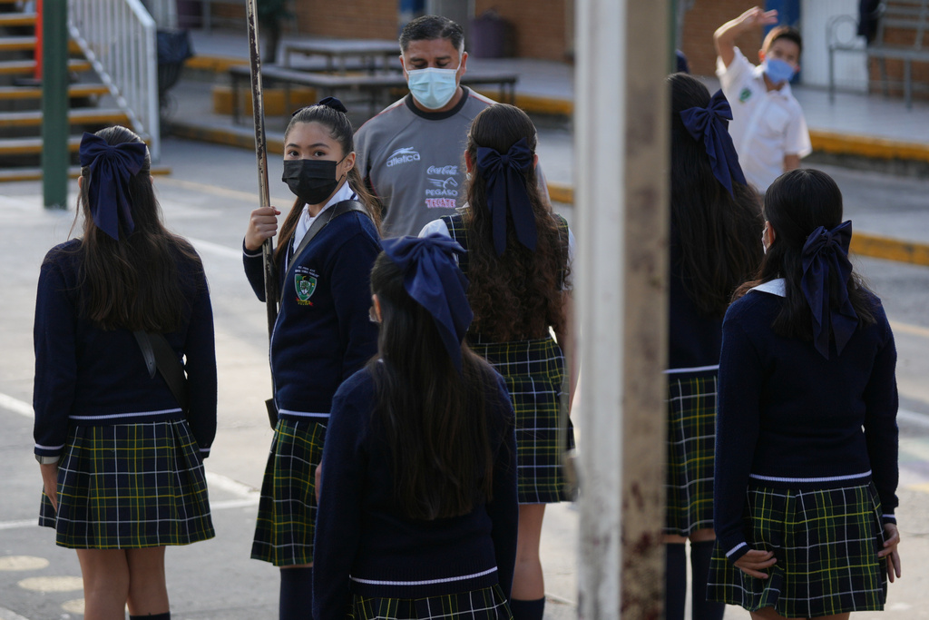 Public school students and teachers wear mandatory face masks amid a measles outbreak, during a ceremony at their school in Guadalajara, Mexico, Thursday, Feb. 5, 2026. (AP Photo/Fernando Llano)