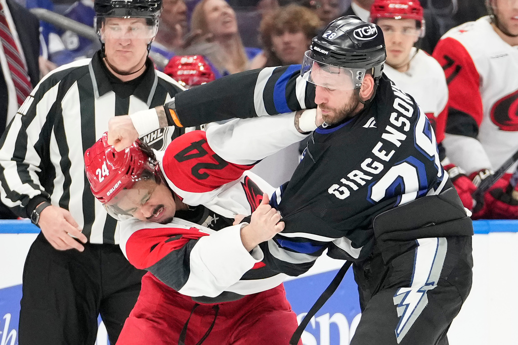 Tampa Bay Lightning center Zemgus Girgensons (28) and Carolina Hurricanes center Seth Jarvis (24) fight during the first period of an NHL hockey game Saturday, March 14, 2026, in Tampa, Fla. (AP Photo/Chris O'Meara)