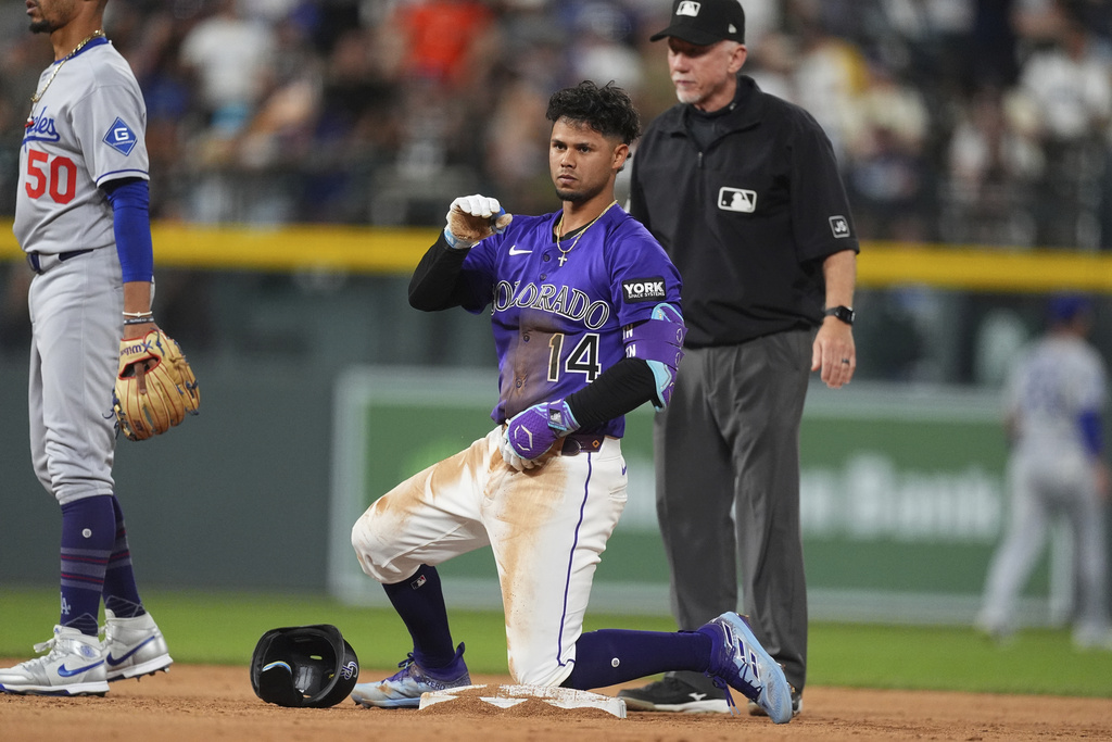 Colorado Rockies' Ezequiel Tovar (14) gestures to the dugout after reaching second base on a double off Los Angeles Dodgers relief pitcher Justin Wrobleski in the ninth inning of a baseball game Monday, Aug. 18, 2025, in Denver. (AP Photo/David Zalubowski)