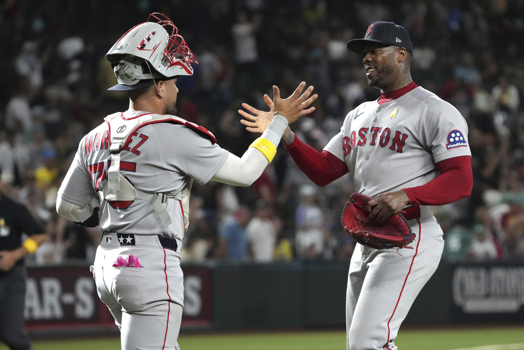 Boston Red Sox catcher Carlos Narváez (75) and pitcher Aroldis Chapman celebrate after defeating the Arizona Diamondbacks during a baseball game, Sunday, Sept 7, 2025, in Phoenix. (AP Photo/Rick Scuteri)