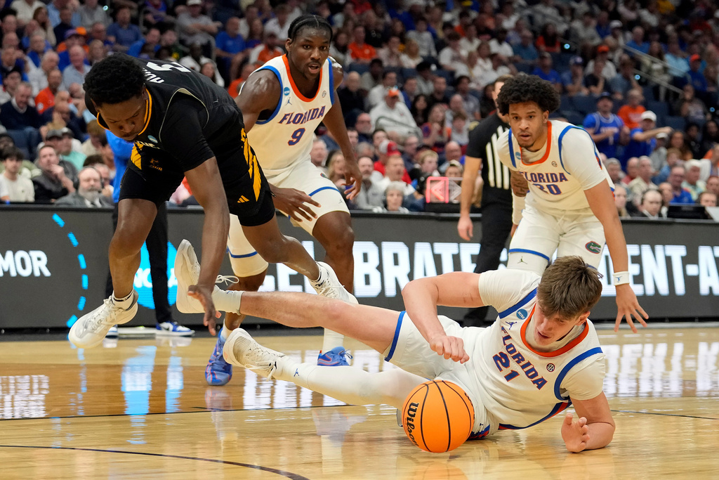 Florida forward Alex Condon (21) picks up a loose ball from Prairie View A M guard Dontae Horne (2) during the first half in the first round of the NCAA college basketball tournament Friday, March 20, 2026, in Tampa, Fla. (AP Photo/Chris O'Meara)