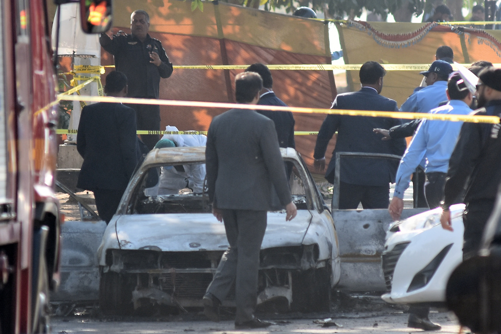 Pakistan's police officers and lawyers gather at the site following a suicide bombing outside the gates of a district court, in Islamabad, Pakistan, Tuesday, Nov. 11, 2025. (AP Photo/W.K. Yousufzai)
