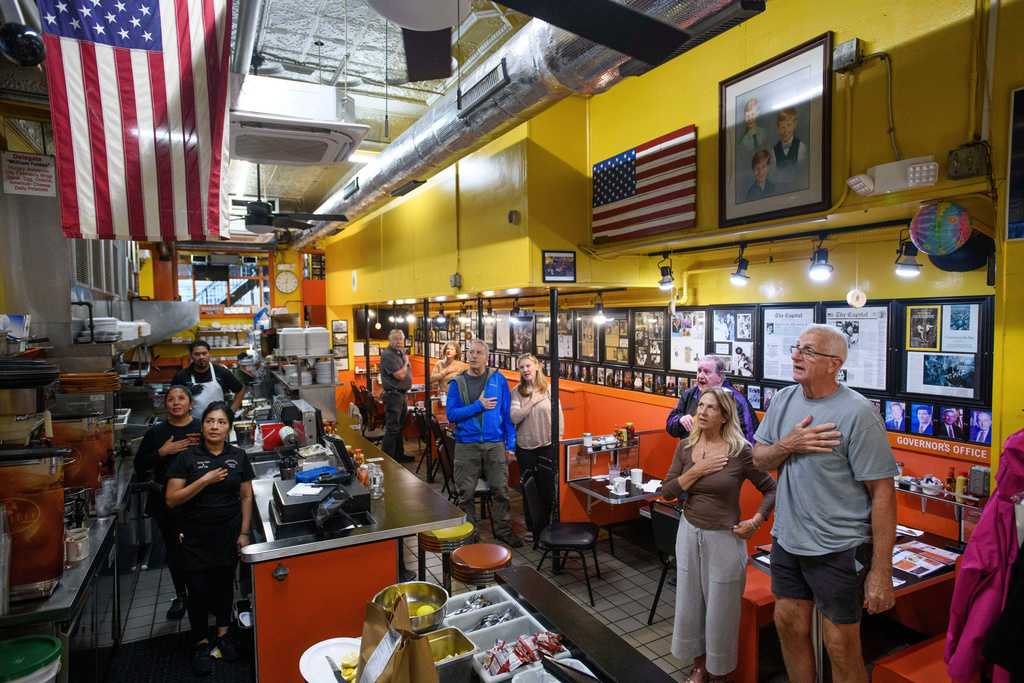On the 24th anniversary of the 9/11 terrorist attacks, customers and employees stand for the daily Pledge of Allegiance at Chick & Ruth's Delly, where has been recited in the morning, seven days a week since 1989, in Annapolis, Md., Thursday, Sept. 11, 2025. (AP Photo/Rod Lamkey, Jr.)