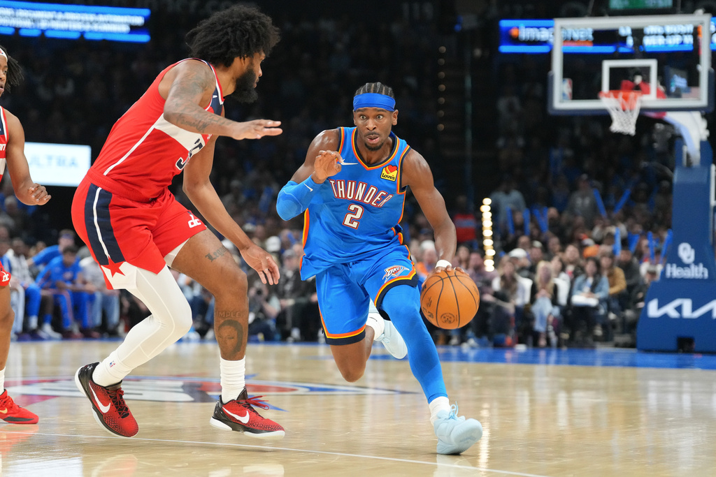 Oklahoma City Thunder guard Shai Gilgeous-Alexander, right, drives past Washington Warriors forward Marvin Bagley III, left, during the second half of an NBA basketball game, Thursday, Oct. 30, 2025, in Oklahoma City. (AP Photo/Kyle Phillips)