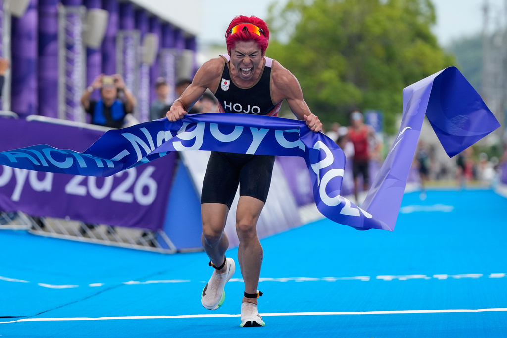 Takumi Hojo of Japan reacts as he wins during the men's individual triathlon at the Asian Games in Gamagori, Japan, Sunday Sept. 20, 2026. (AP Photo/Dita Alangkara)