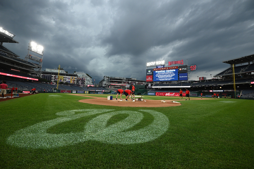 The Washington Nationals grounds crew works on the field as the baseball game between the Washington Nationals and the Toronto Blue Jays is being delayed due to inclement weather in the area, Tuesday, July 28, 2026, in Washington. (AP Photo/Nick Wass)