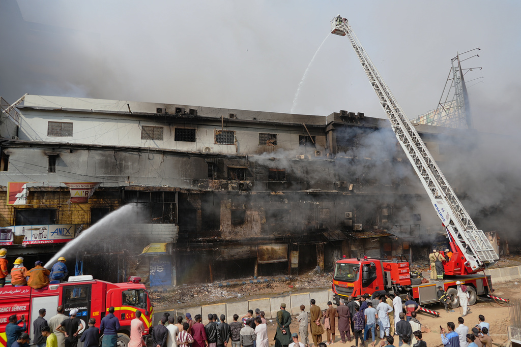 Firefighters try to control a massive fire that was broke out in a multi-story shopping mall in overnight, in Karachi, Pakistan, Sunday, Jan. 18, 2026. (AP Photo/Mohammad Farooq)