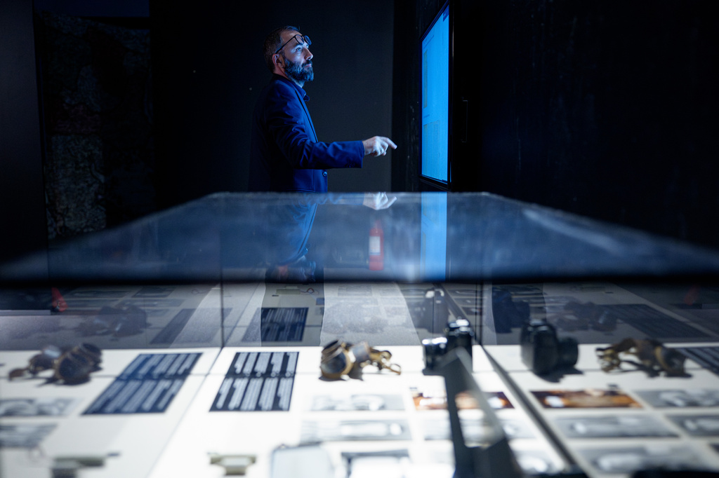 Cornel Constantin Ilie, manager of the National History Museum of Romania looks at a display during the opening of the "A.REST 1989 — The Securitate Video Archive" exhibition, at the National History Museum of Romania, in Bucharest, Romania, Tuesday, June 16, 2026. (AP Photo/Andreea Alexandru)
