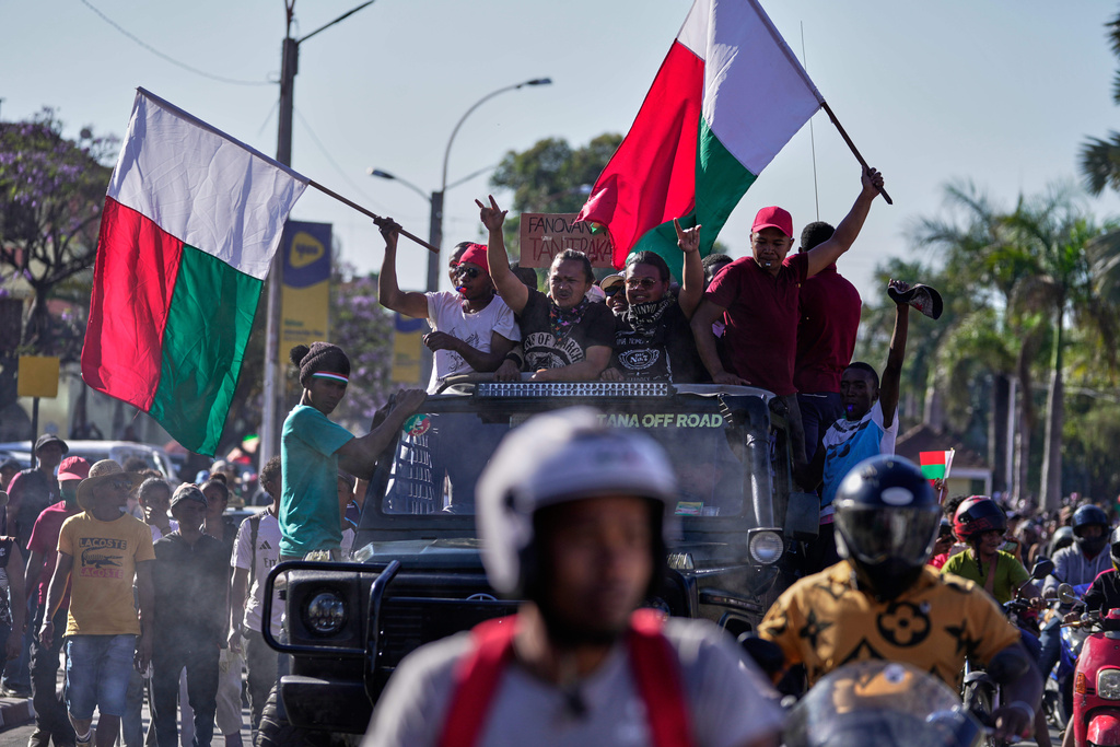 Protesters dance on top of a car during a protest calling for President Andry Rajoelina to step down in Antananarivo, Madagascar, Tuesday, Oct. 14, 2025. (AP Photo/Brian Inganga)