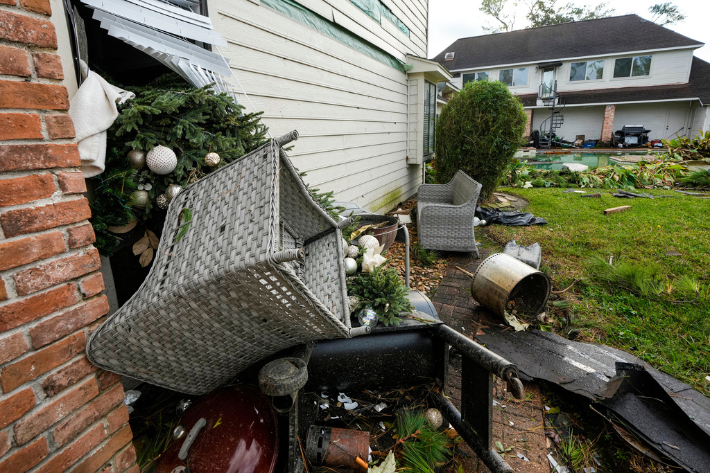 A Christmas tree was sucked out the back window of Guillermo Vargas' home after at storm swept through the Memorial Northwest subdivision, in Spring, Texas, Monday, Nov. 24, 2025. (Brett Coomer/Houston Chronicle via AP)