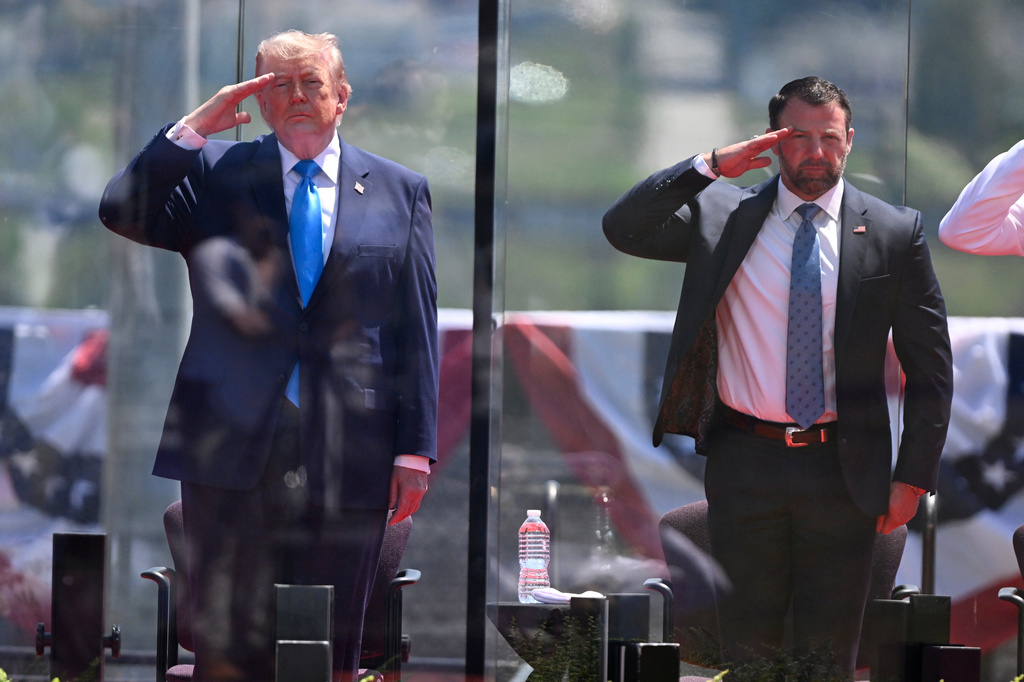President Donald Trump, left, and Secretary of Homeland Security Markwayne Mullin, right, saluting at the start of the commencement ceremony at the U.S. Coast Guard Academy in New London, Conn., Wednesday, May 20, 2026. (AP Photo/Jessica Hill)