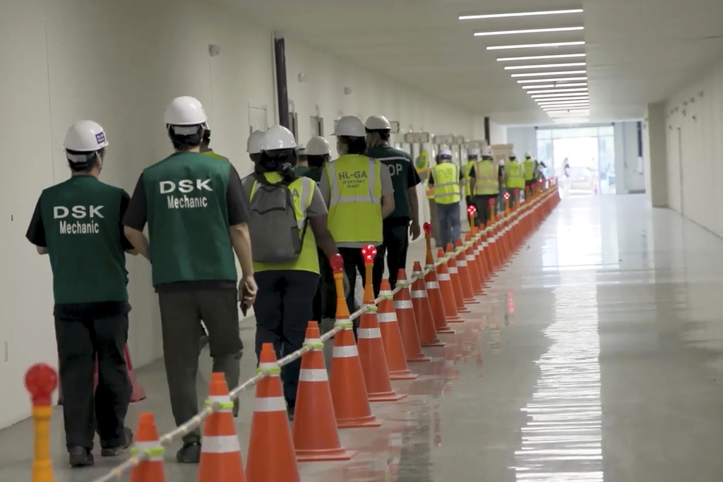 This image from video provided by U.S. Immigration and Customs Enforcement via DVIDS shows manufacturing plant employees being escorted outside the Hyundai Motor Group’s electric vehicle plant, Thursday, Sept. 4, 2025, in Ellabell, Ga. (Corey Bullard/U.S. Immigration and Customs Enforcement via AP)
