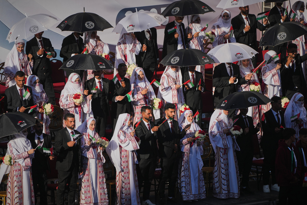 Palestinian couples participate in a mass wedding ceremony in Hamad City in Khan Younis, Gaza Strip, Tuesday, Dec. 2, 2025. (AP Photo/Abdel Kareem Hana)
