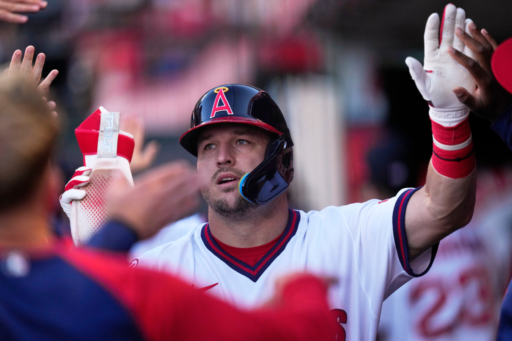 Los Angeles Angels' Mike Trout is congratulated by teammates in the dugout after scoring on a double by Jorge Soler during the first inning of a baseball game against the St. Louis Cardinals, Tuesday, July 21, 2026, in Anaheim, Calif. (AP Photo/Mark J. Terrill)