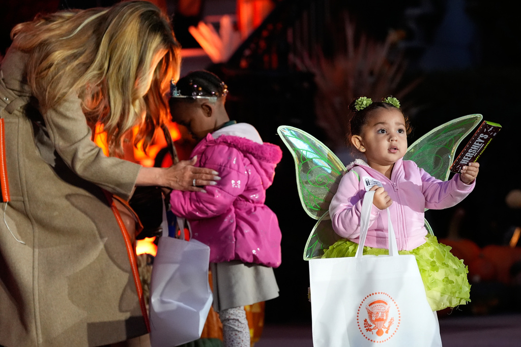 First lady Melania Trump talks with a child as she and President Donald Trump participate in a Halloween at the White House event on the South Lawn, Thursday, Oct. 30, 2025, in Washington. (AP Photo/Alex Brandon)