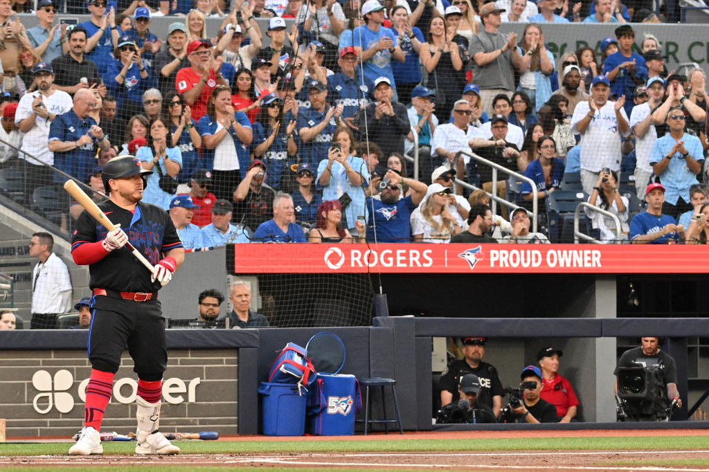 Toronto Blue Jays' Alejandro Kirk, left, is met with applause while taking his first at-bat since retuning to the lineup from the injured list during the first inning of a baseball game against the New York Yankees in Toronto, Friday, June 12, 2026. (Jon Blacker/The Canadian Press via AP)