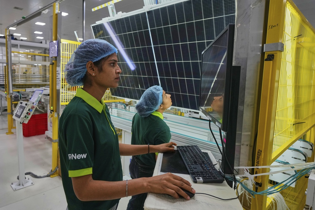 Workers check the quality of a solar panel at the production line up at a ReNew manufacturing plant on the outskirts of Jaipur, India, Thursday, Aug. 21, 2025. (AP Photo/Manish Swarup)