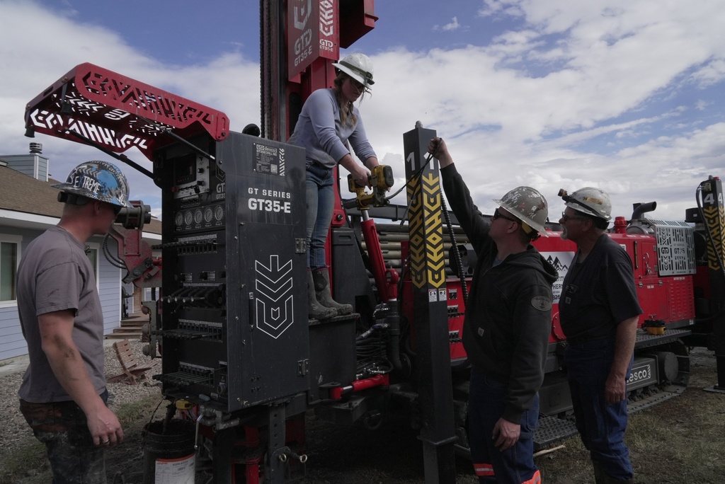 Matthew, Anna, Nathan and Matt Cooper prepare to drill a hole for a geothermal heat pump installation Thursday, Oct. 9, 2025, in Hamilton, Colo. (AP Photo/Brittany Peterson)
